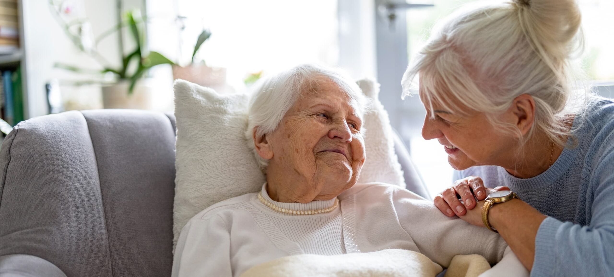 Two women look at each other smiling, one older than the other