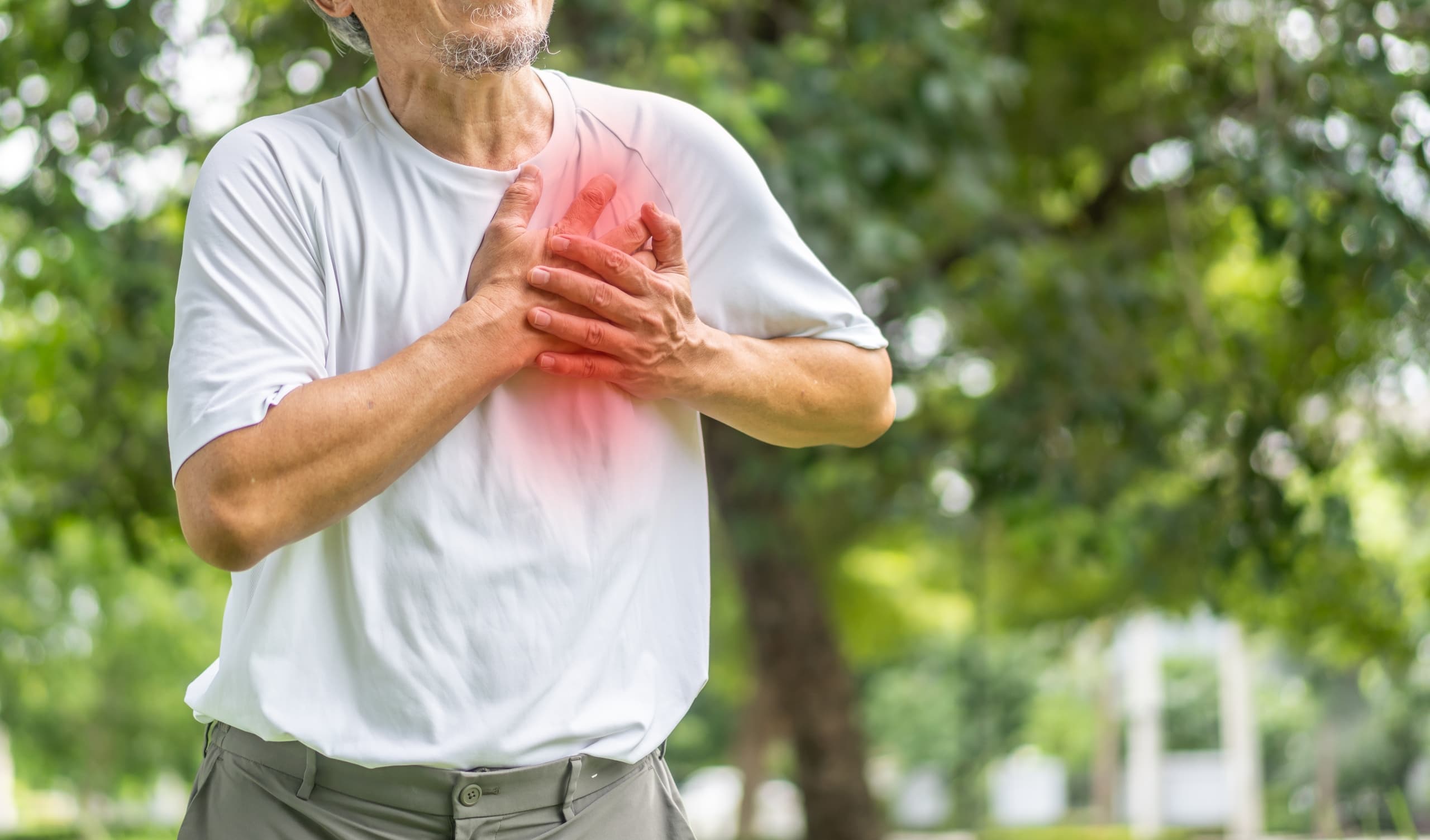 A man clasps his hands on his chest over his heart with a red color showing pain