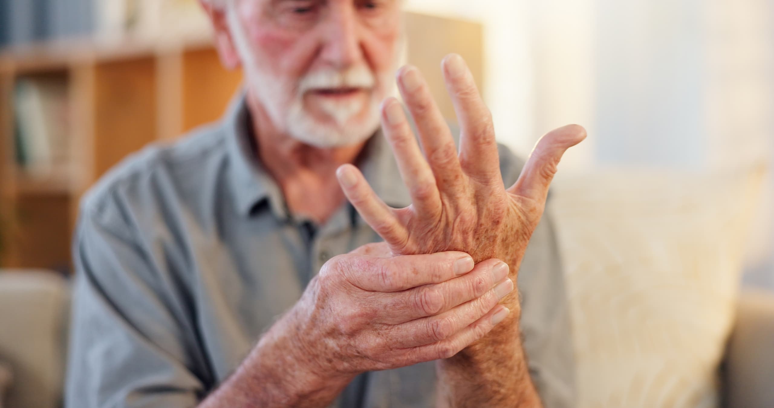 A man looks at and holds his hand